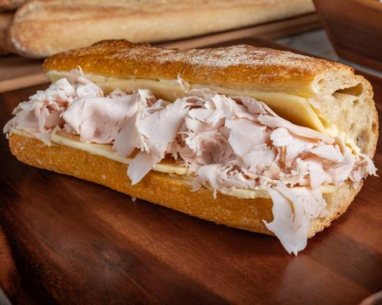 Submarine sandwich with turkey and cheese on a wooden board