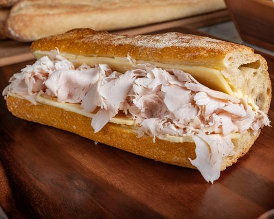 Submarine sandwich with turkey and cheese on a wooden board