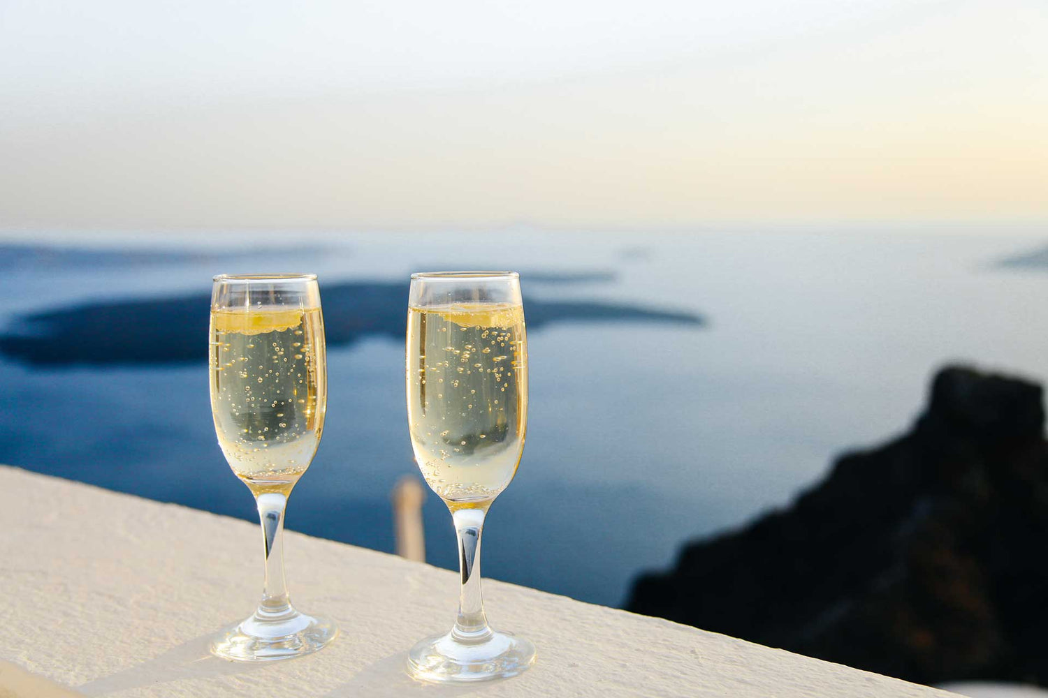 Two glasses of Champagne in front of an ocean view. 